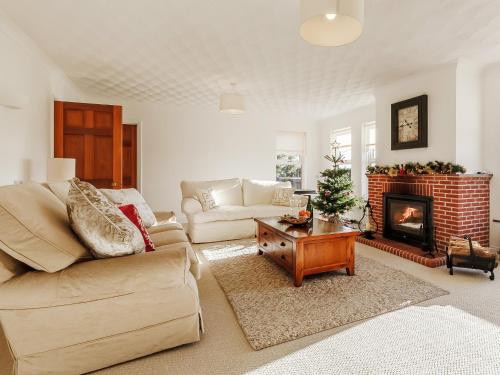 a living room with a couch and a fireplace at Highgrove in Gissing