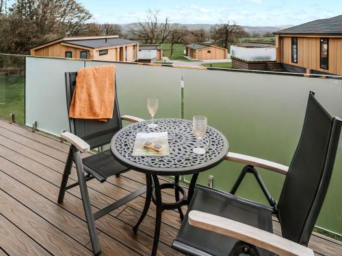 a table and chairs on a balcony with a table and glasses at Kiri - Uk51106 in Clitheroe