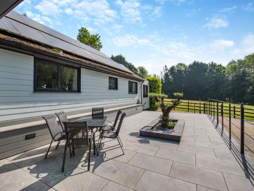 a patio with a table and chairs and a house at Foxton Barn - Uk47297 in Harrietsham