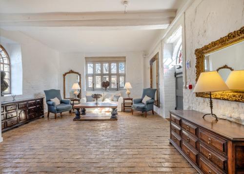 a living room with chairs and a table and a mirror at Oxnead Hall in Brampton