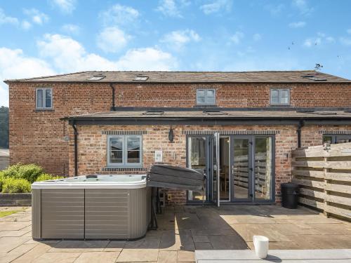 a brick house with a hot tub in front of it at Cor Tarw - Uk12743 in Acrefair