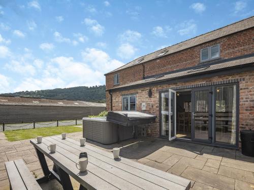 a brick building with a grill and a wooden deck at Cor Tarw - Uk12743 in Acrefair
