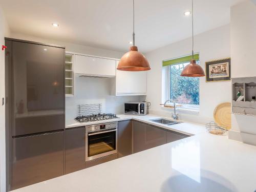 a kitchen with stainless steel appliances and brown cabinets at Strugglers Retreat - Uk32878 in Lincoln