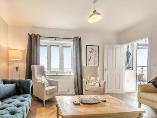 a living room with a couch and chairs and a table at Sandbanks in Bridlington