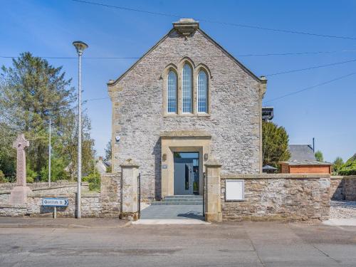 an old stone church with a sign in front of it at Auld Kirk House in Duns