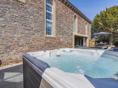 a hot tub in front of a brick building at Auld Kirk House in Duns