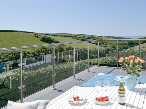 a patio with a table and a bottle of wine at Roskear in Crackington Haven