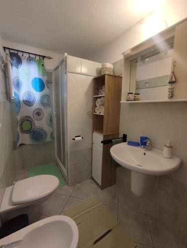 a bathroom with a sink and a toilet and a shower at Appartamenti Conchiglie e Stelle Marine in Cala Gonone