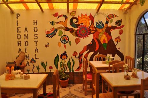 a restaurant with tables and a mural on the wall at Hostal Piedra Andina in Copacabana