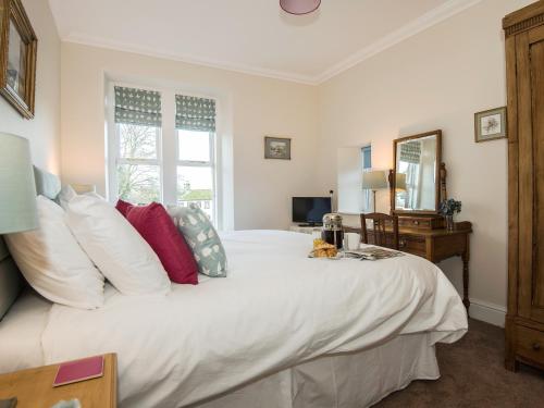 a bedroom with a large white bed with red pillows at The Laburnums in Askham