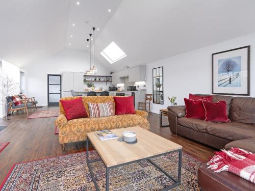 a living room with two couches and a table at Bimblebox Stable in Reepham
