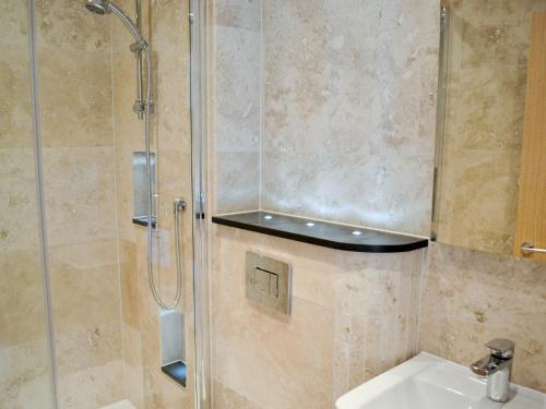 a bathroom with a shower and a sink at Gylly Beach View - Tor in Falmouth