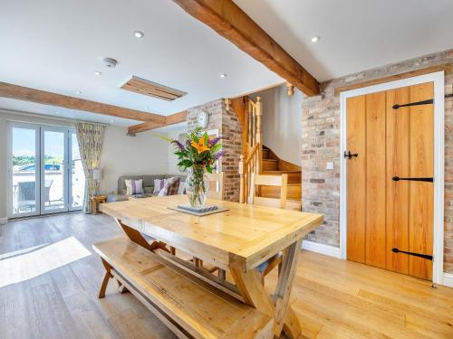a living room with a wooden table with a vase of flowers at The Rose- Uk47155 in Burgh le Marsh