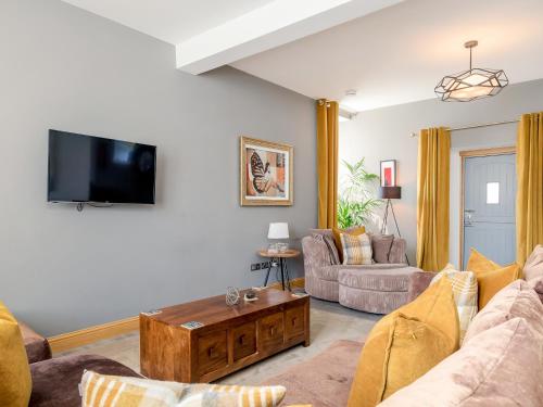 a living room with a couch and a tv at Formans Lodge in Musselburgh