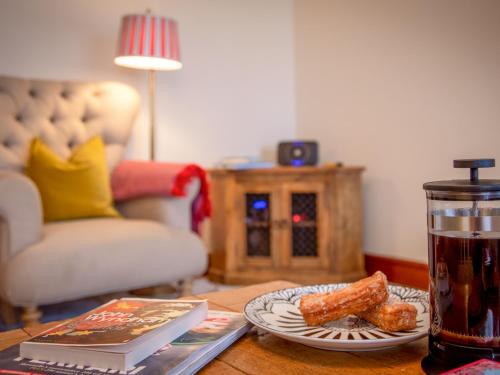 a table with a drink and a plate of food at Willow Cottage-Uk2788 in Penmaen-mawr