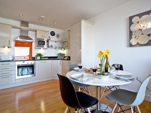 a kitchen and dining room with a white table and chairs at 42 Ocean 1 in Crantock