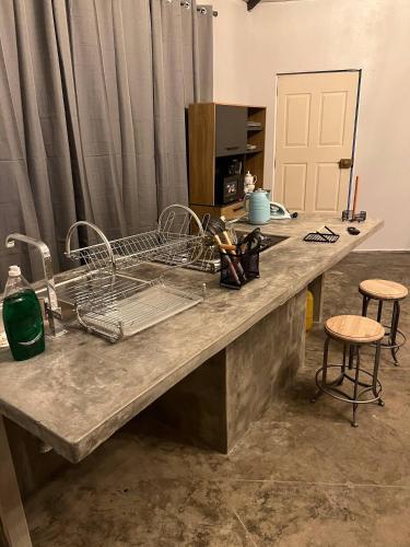 a kitchen with a counter with dishes and stools at MERs house enjoys nature in Cajamarca