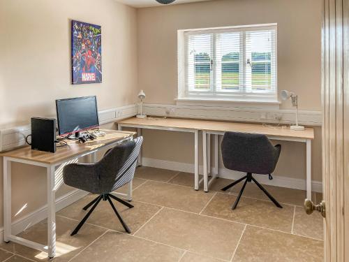 a home office with a desk and two chairs at Barnyard in Chetnole