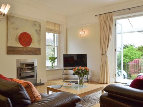 a living room with a couch and a tv at Carnethic House - One Acre View in Fowey