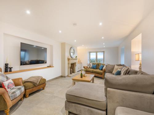 a living room with couches and a flat screen tv at Whiteoak Cottage in Rawdon