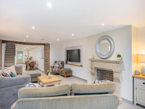 a living room with two couches and a fireplace at Whiteoak Cottage in Rawdon