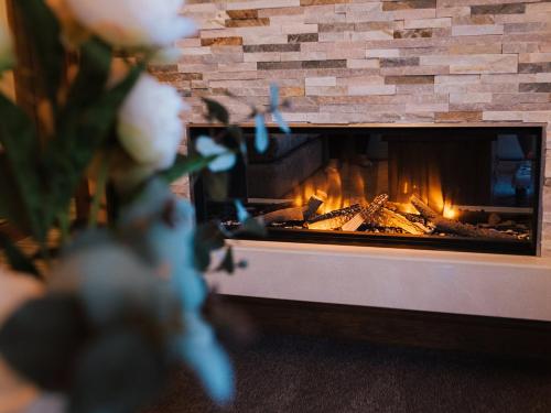 a brick fireplace with a fire in it at Cedar Barn - Uk33352 in Buttershaw