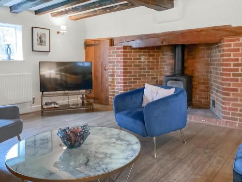 a living room with a blue chair and a fireplace at Smallbrook Cottage - Uk50922 in Salisbury