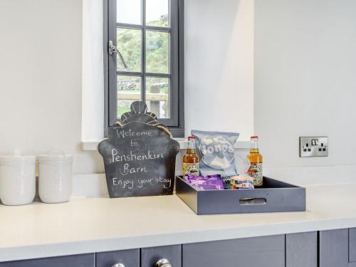 a kitchen counter with a box of complimentary beer at Penshenkin Barn in Llanfihangel-nant-Melan