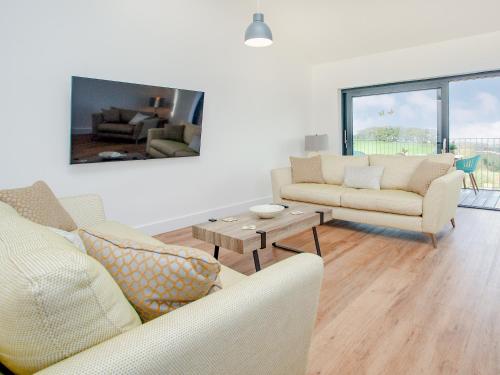 a living room with two couches and a table at Foxglove-Uk34612 in Nether Stowey