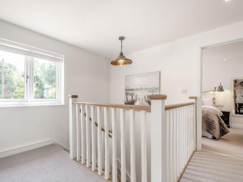 a white room with a staircase and a bed at Pennyard House in Banwell