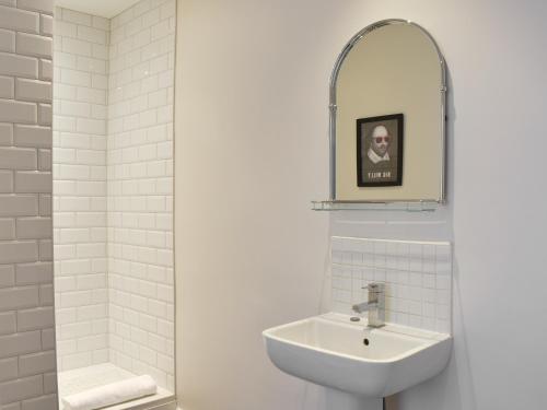 a white bathroom with a sink and a mirror at Brittain House in Richmond