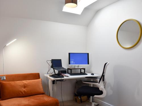 an office with a desk with a computer and a mirror at Brittain House in Richmond