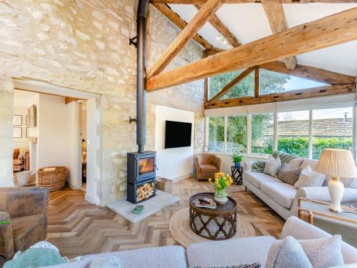 a living room with a fireplace and a stone wall at Badger Hill Barn in Malham
