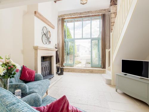 a living room with a blue couch and a television at The Hall - Uk32690 in Horton