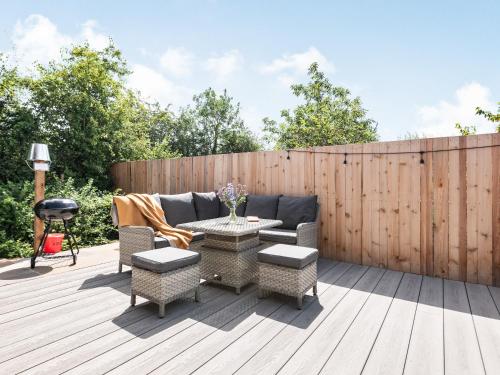 a patio with a couch and tables and a fence at Silhouette's Stable - Uk34102 in Chichester