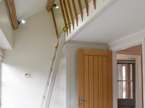 a staircase in a house with a wooden door at Trezeal Barn in North Hill