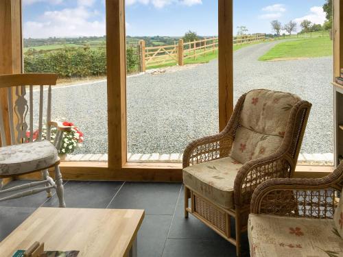 a screened in porch with two chairs and a table at Trezeal Barn in North Hill