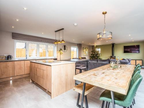 a kitchen and living room with a wooden table at The Hazels - Ukc4614 in Dunholme