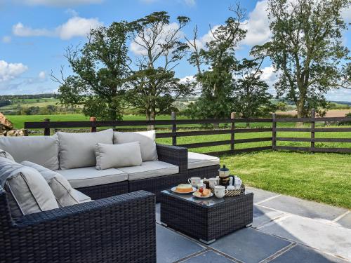 a patio with a couch and a table and a fence at Swiss Cottage in Lancaster