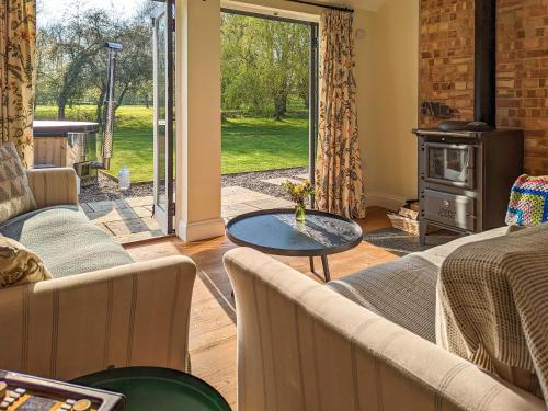 a living room with couches and a wood stove at The Stables - Uk50804 in Halesworth