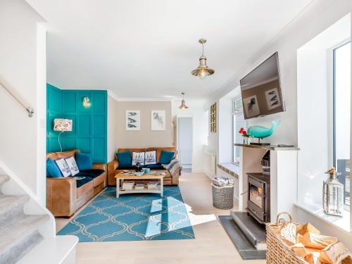 a living room with a couch and a fireplace at Tregarrek in Coverack