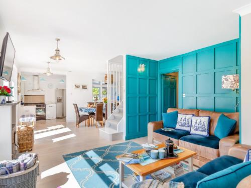 a living room with blue walls and a couch at Tregarrek in Coverack