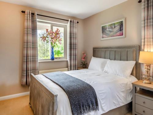 a bedroom with a bed and a window at Dunburgh Wood in Beccles