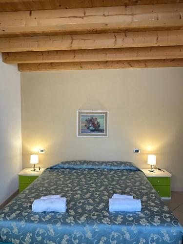 a bedroom with a blue bed with two lamps at Locanda Graziella in Moerna