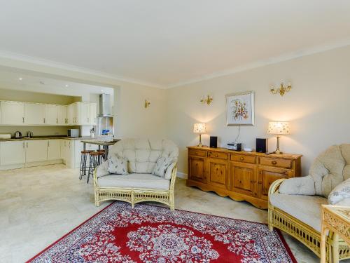 a living room with two chairs and a kitchen at Henrys Retreat in Ingoldsby