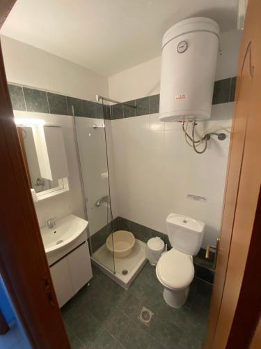 a bathroom with a toilet and a sink and a shower at Nelli rooms in Polychrono