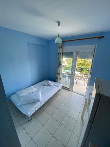 a blue room with a bed and a balcony at Nelli rooms in Polychrono