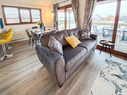 a living room with a leather couch and a table at River Breeze-B6853 in Brundall