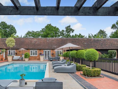 an exterior view of a house with a swimming pool at The Barn - Uk49371 in Send