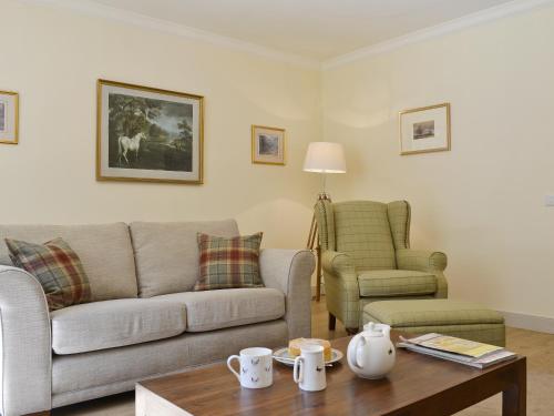 a living room with a couch and a table at Curlew Cottage in Meigle